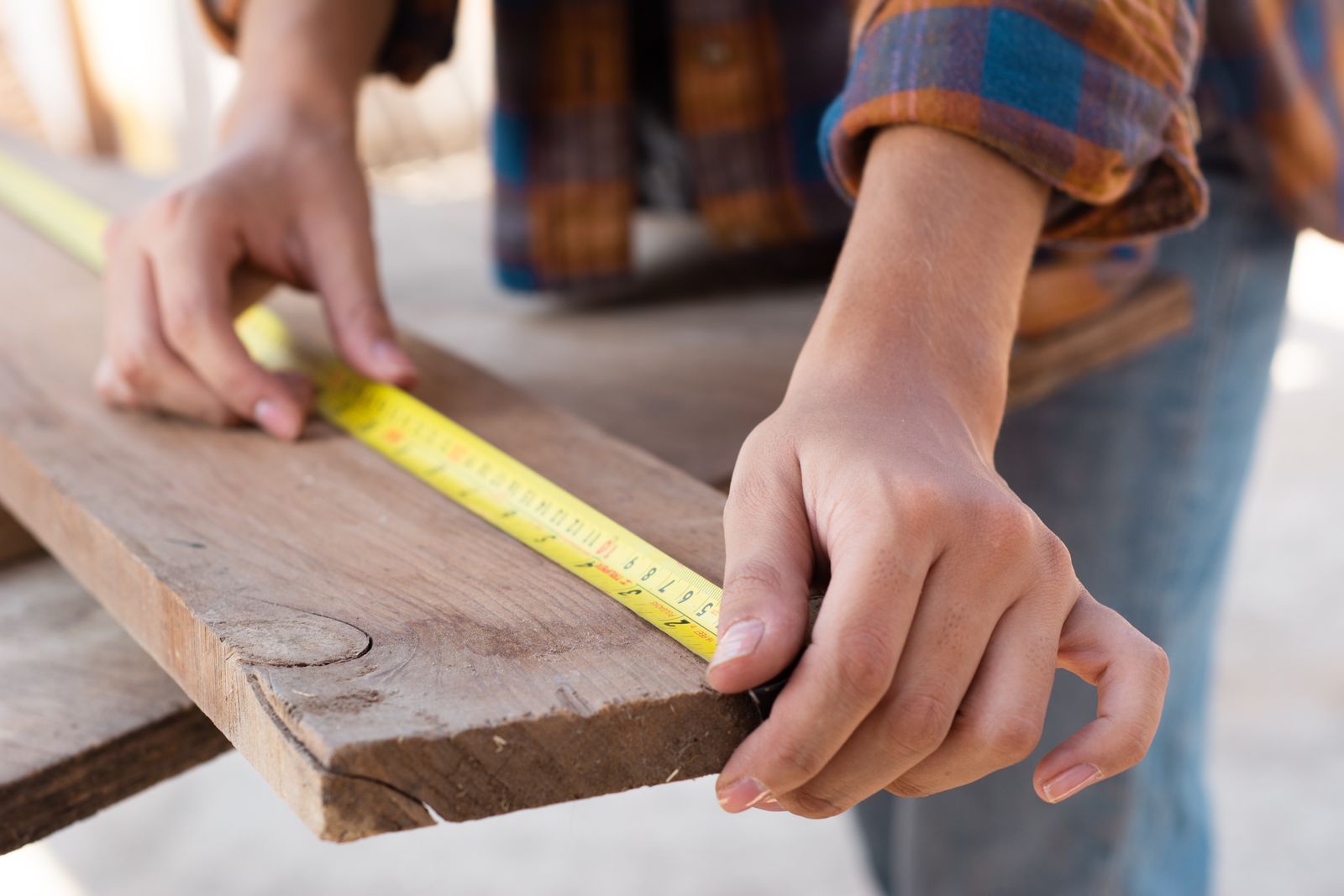 Close-up of measuring a wood plank for per-foot pricing