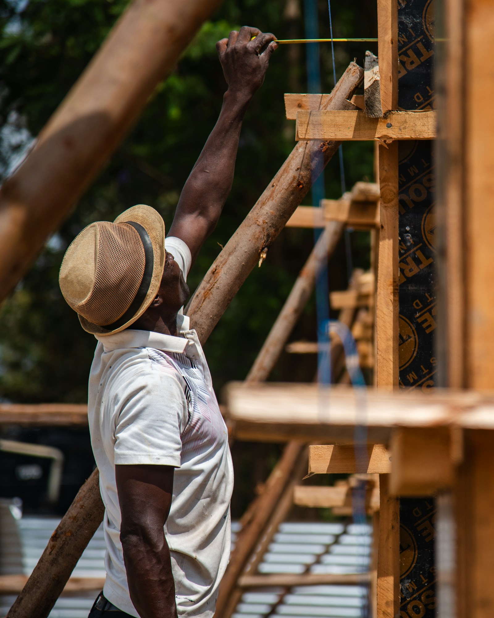 Owner-operator carpenter measuring lumber on a job site